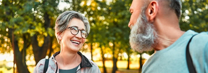 Chiropractic Service Area TN Family in the park Two older adults walk and talk in a tree-lined park