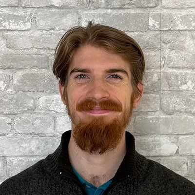 Dr. Jack Howard smiling in front of a brick wall