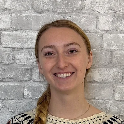 Dr. Mary Howard smiling in front of a brick wall.